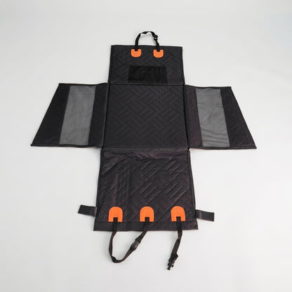 Flat-lay view of the Nordic Cloud waterproof travel bed fully unfolded, displaying the multi-panel design, mesh sides, and orange fastening straps.